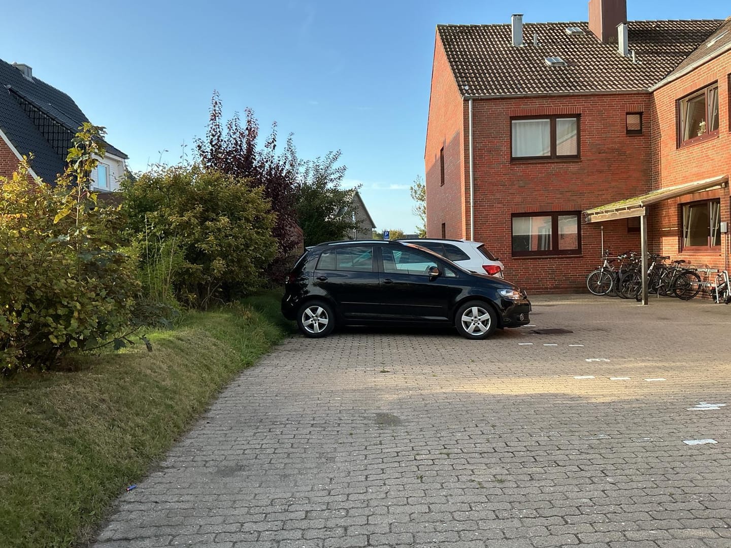 Die Stellplätze auf der Rückseite des Gebäudes: Ihr eigener Platz Nr. 3 ist im Preis enthalten, daneben der überdachte Fahrradstand.