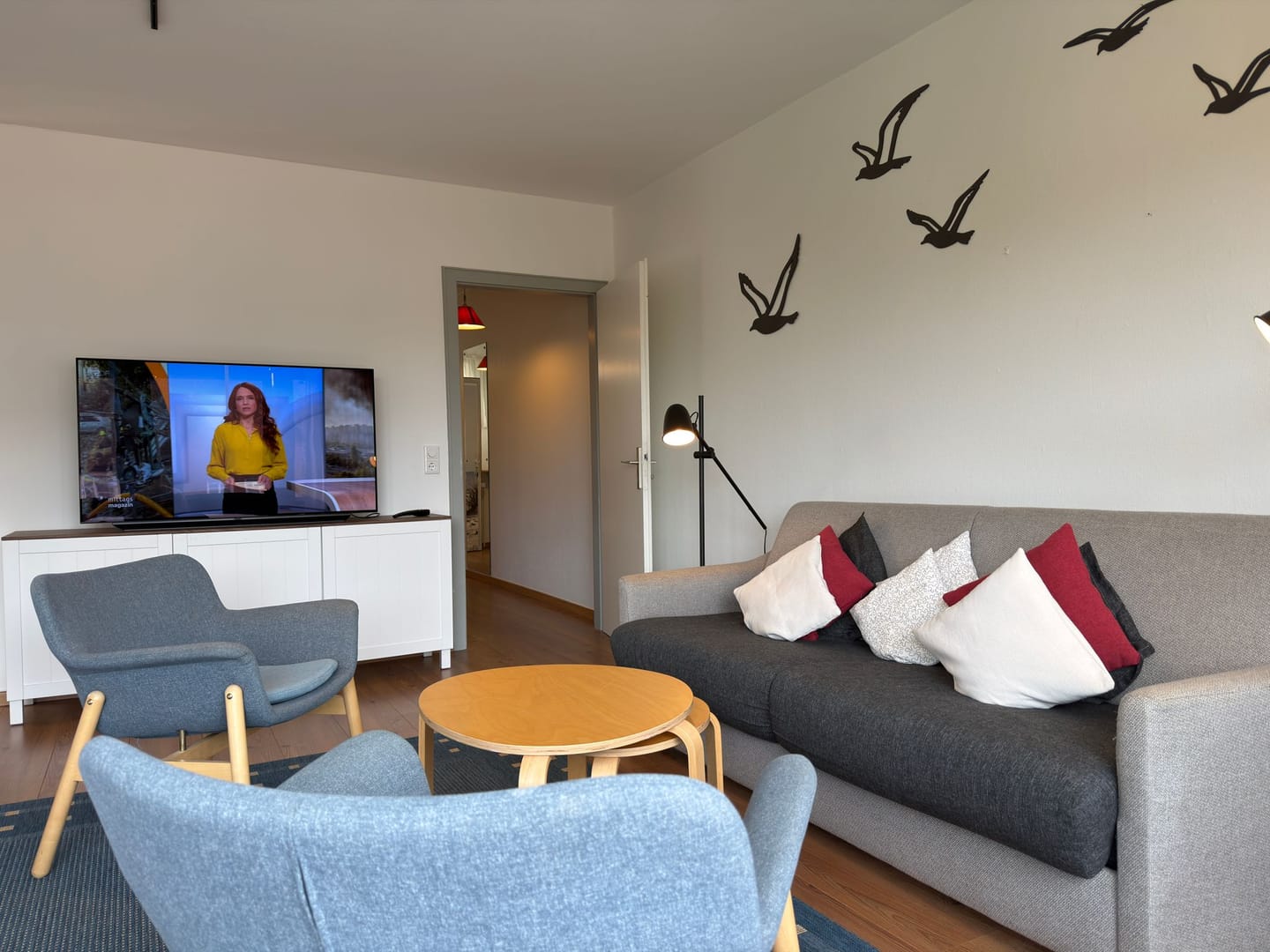 Sofa-Ecke mit Möwen-Wanddeko und Blick in den Flur